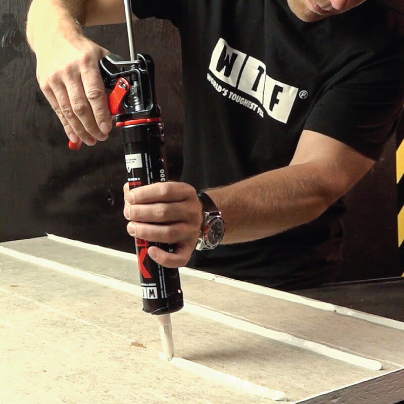 man using adhesive with a glue gun